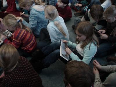 More JFKS 4th grade students looking at pictures of children in the Souleiada initiative